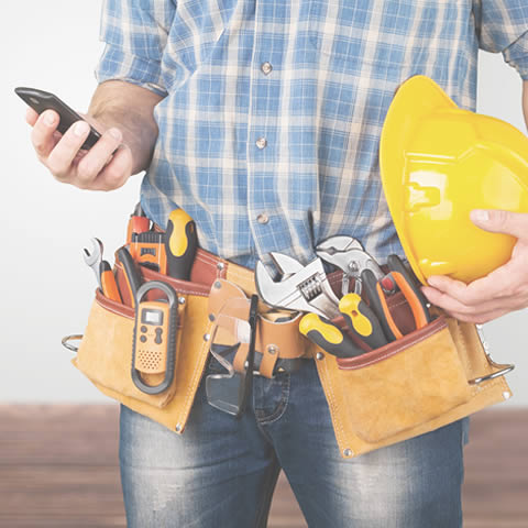 Electricien professionnel passant un appel téléphonique avec son smartphone